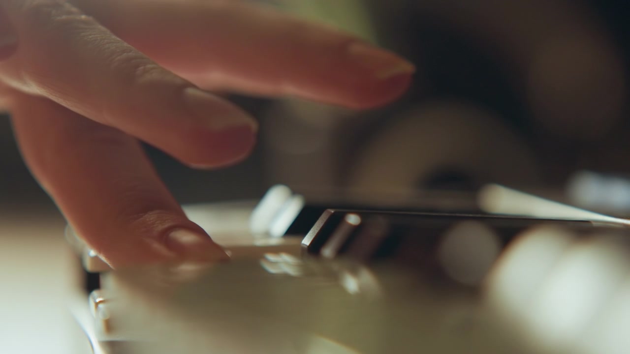 Low angle close view of fingertips pressing glossy black and white piano keys with clear downward movement, slight key depression, soft warm light, and focused practice atmosphere, with piano, keys