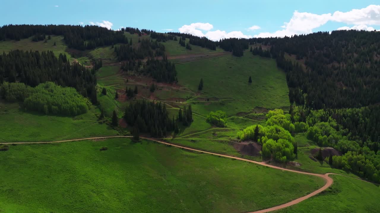4wd road Little Annie Trailhead Aspen Mountain Ajax Richmond Hill cabins aerial drone Colorado Rocky Mountains Aspen Trees grove Mountain spring summer morning blue sky clouds circle left motion