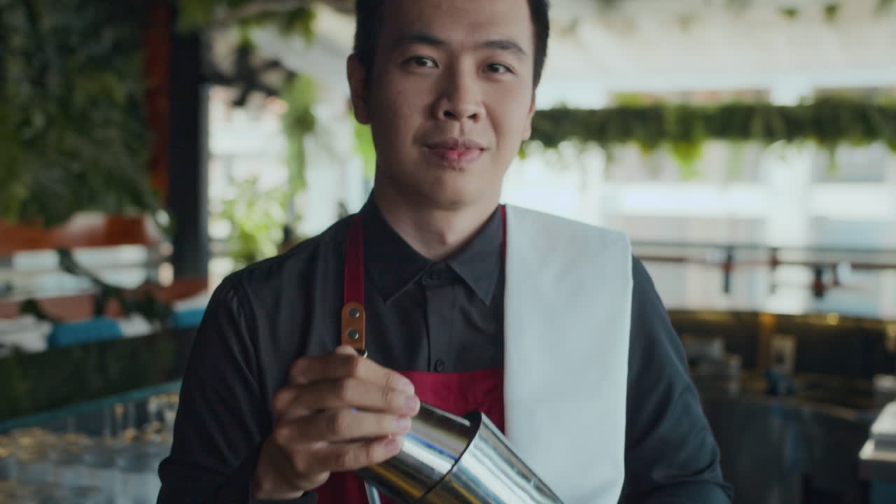 Portrait of Young Barman Smiling behind Bar