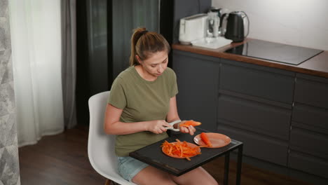woman peeling carrots in kitchen