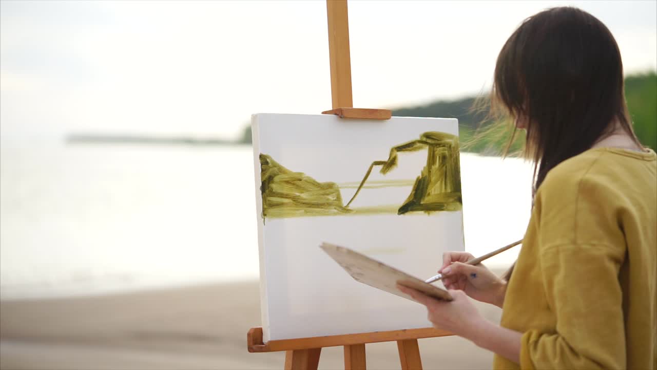 해변 에 바다 풍경 을 그리는 여자