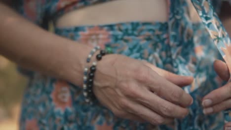 A-close-up-dolly-shot-following-along-the-torso-and-body-of-an-attractive-Caucasian-female-wearing-a-beautiful-floral-summers-dress