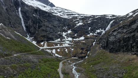 Paso-De-Montaña-Trollstigen-Días-Antes-De-Abrir-Con-Nieve-En-El-Terreno---Antena-Acercándose-A-La-Ladera-Sobre-La-Carretera-Cerrada