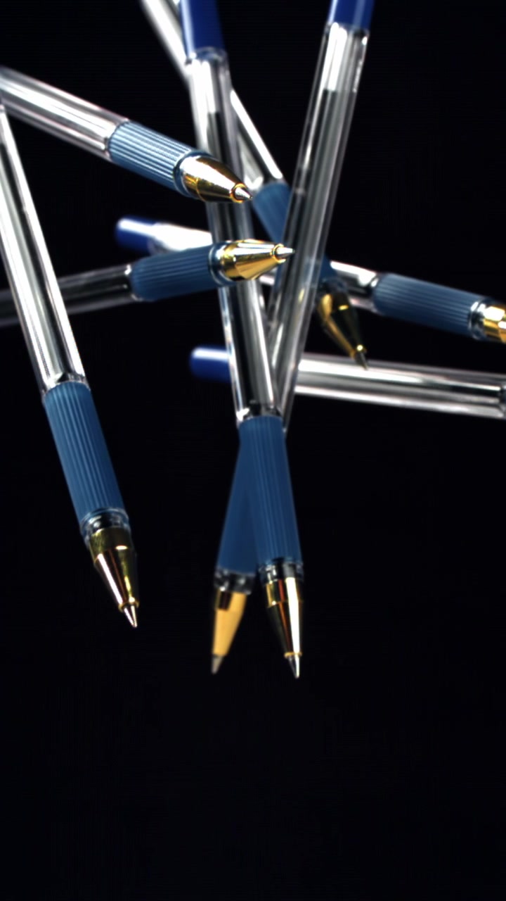 Abstract Arrangement of Blue and Gold Ballpoint Pens on Black Background