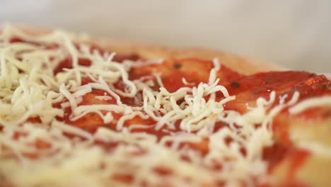 adding grated cheese to pizza topping, extreme close up with copy space