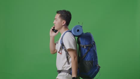 hombre con mochila hablando por teléfono