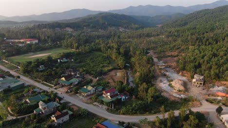 圍繞著樹木,靠近大山的鄉村村莊的空中拍攝