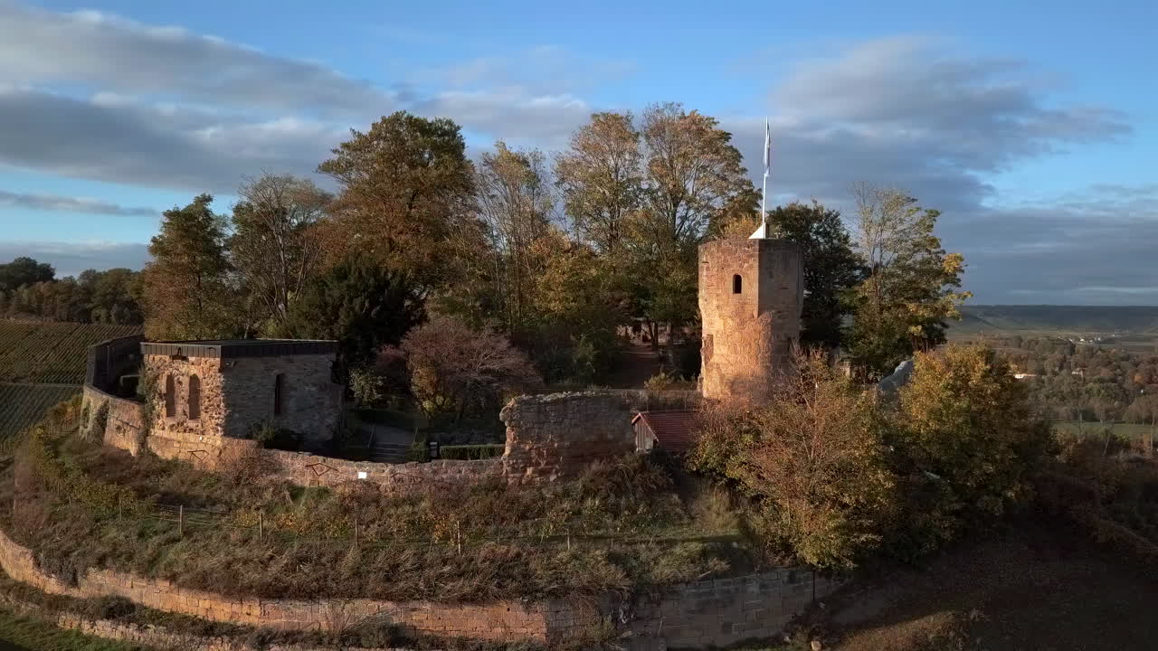 Orbiting shot of the medieval castle ruin 'Weibertreu' on a hill near the village ‚Weinsberg‘ in warm autum colors on a sunny day