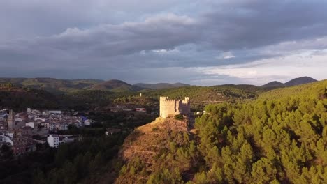 pequeño castillo islámico en la cima de una colina iluminada durante la puesta de sol