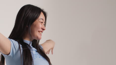 Side-View-Of-Group-Of-Young-Woman-In-Front-Of-White-Studio-Background-Posing-For-Photo-Booth-Style-Portraits