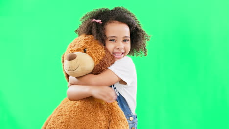Happy,-little-girl-and-hugging-teddy-bear-on-green