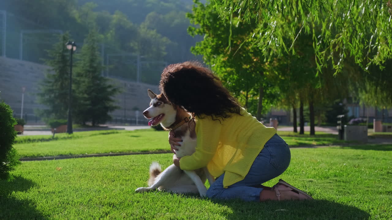 mujer abrazando a su perro husky en un parque