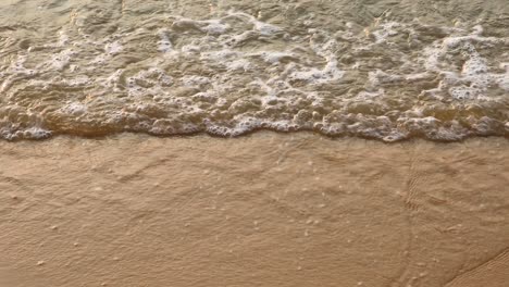 ocean waves crash on the sandy beach in pattaya, thailand