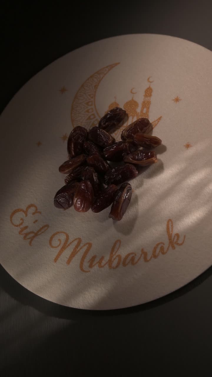 Muslim person taking a date from a traditional plate during Ramadan for an Iftar meal at night