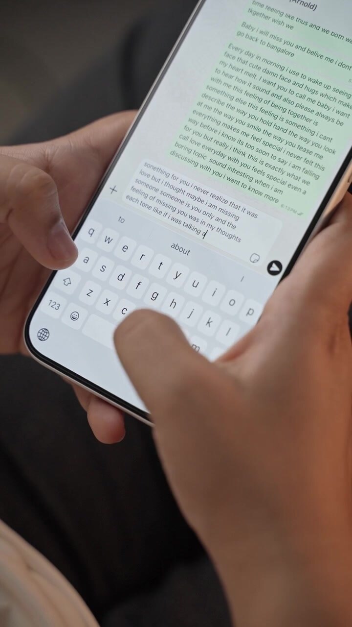 Woman's hand chatting and typing on a smartphone, macro closeup. Unrecognisable human typing a text message, tapping the touchscreen keyboard using the WhatsApp application, a social media.