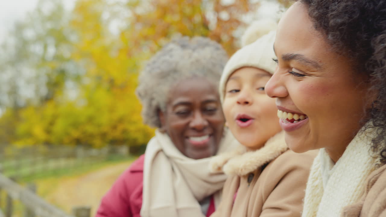 Portrait of multi-generation female family standing by gate on walk through autumn countryside - shot in slow motion