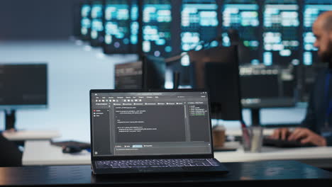 Fokus-Auf-Dem-Laptop,-Der-Von-Einem-Experten-Im-Rechenzentrum-Verwendet-Wird-Und-Code-Auf-Unscharfem-Hintergrund-Ausführt