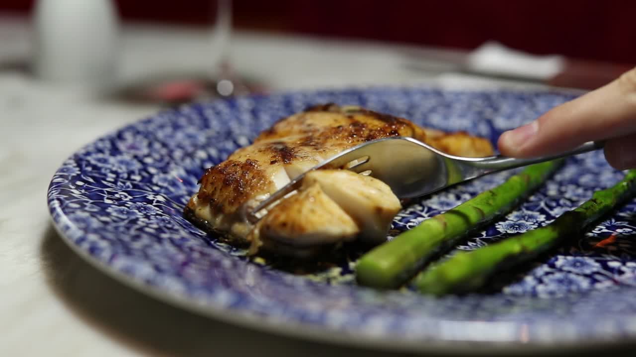 totuava totoaba fish dish cut by fork in restaurant