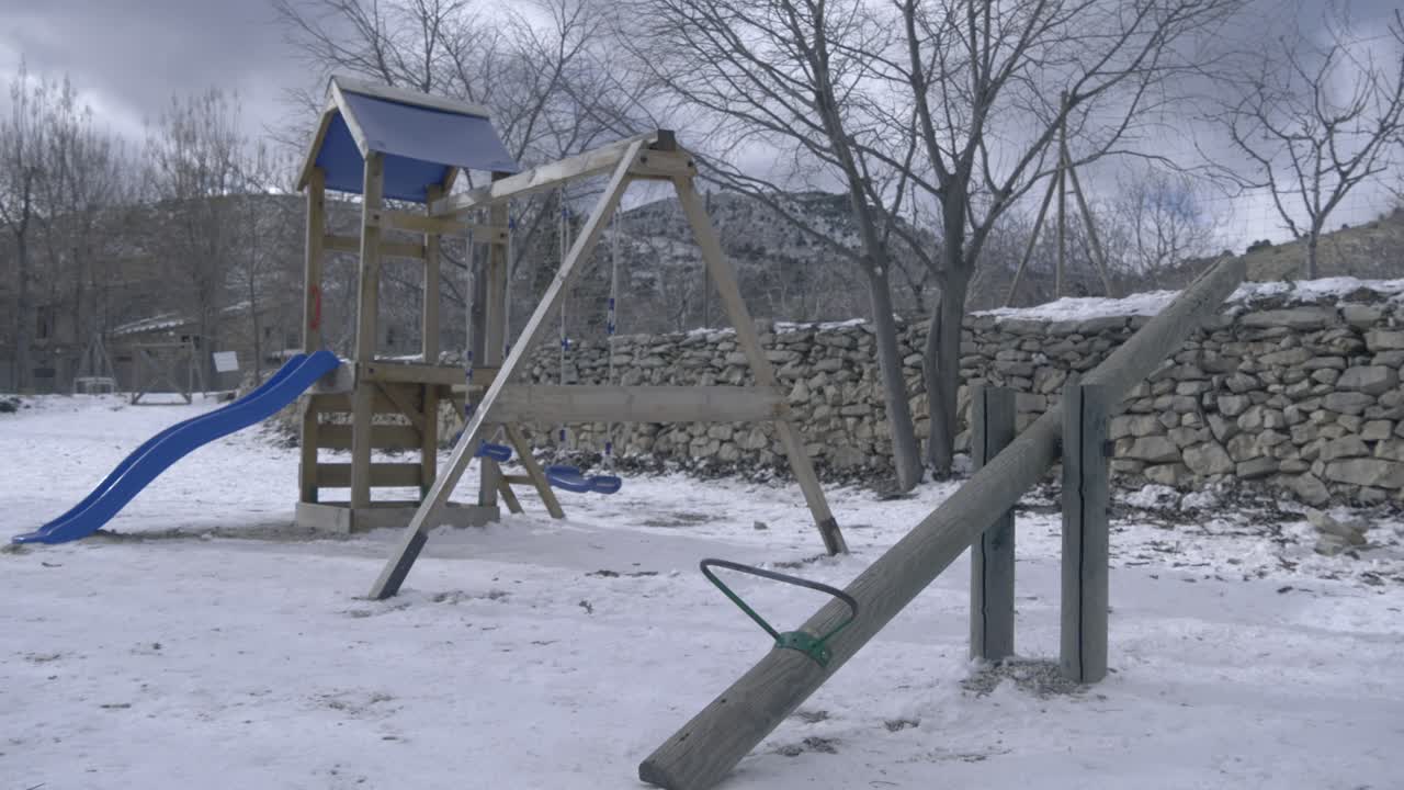 parque infantil vacío con hielo y nieve en el parque