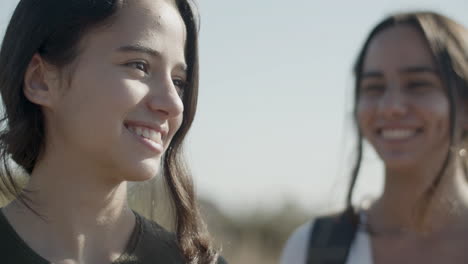 close up of two walking outside, talking and laughing