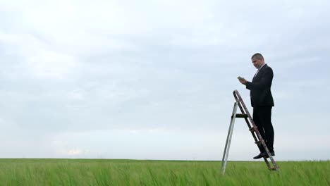 a man is looking for a mobile connection in the middle of the field he climbs a ladder a man is looking for a mobile connection in the middle of the field he climbs a ladder poor internet coverage