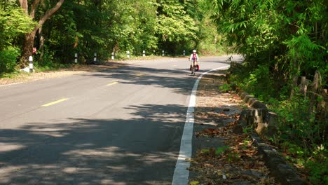 foto de mujeres en bicicleta en la carretera del pueblo de pescadores de pak nai, provincia de nan, tailandia