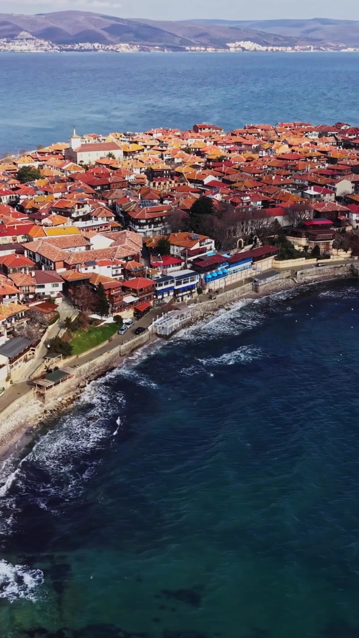 Vista dall'alto di Nesebar con edifici antichi e onde del mare