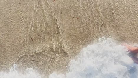 man walking on clean blue flag beach in halkidiki peninsula, greece