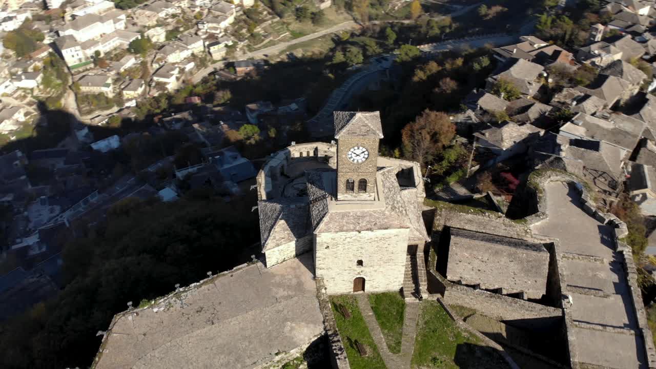torre del reloj del castillo en la cima de una colina rocosa rodeada de casas de piedra de la ciudad de gjirokastra