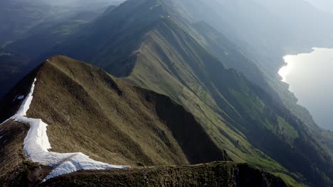 Beautiful-endless-ridge-top-amongst-huge-mountains-and-above-a-green-valley-with-a-blue-lake