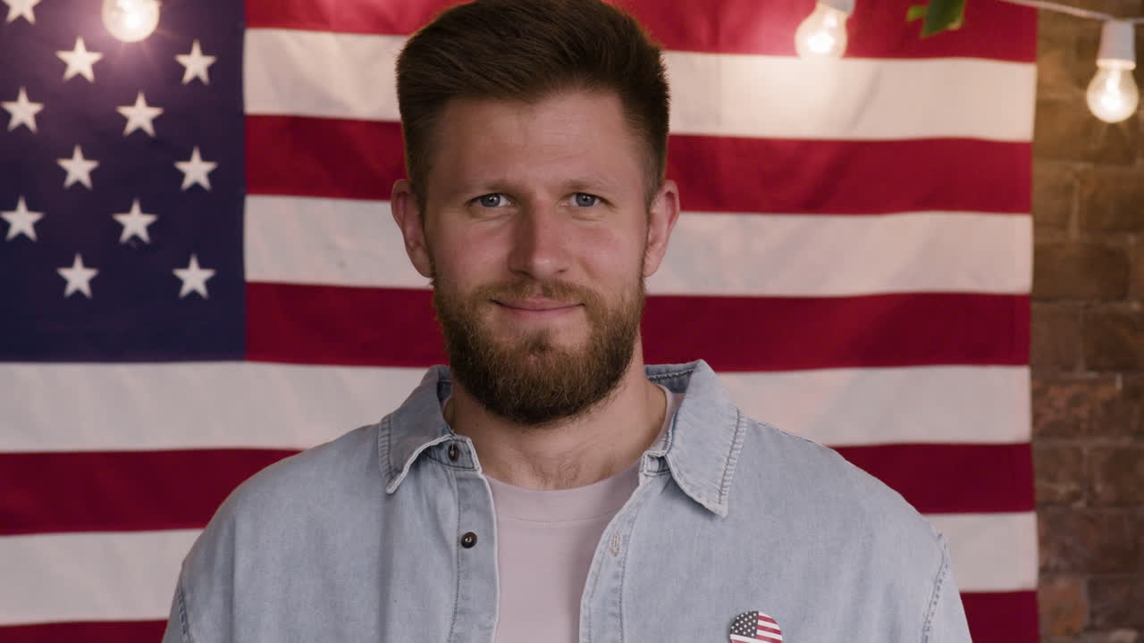 Man Holding a Hot Dog in Front of American Flag