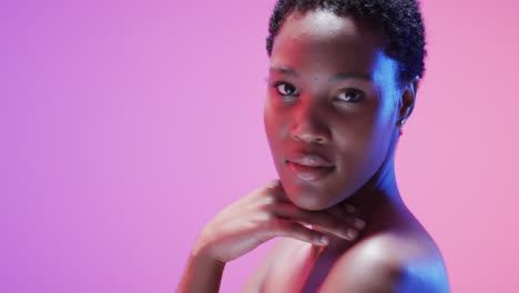mujer afroamericana con cabello oscuro corto en luz azul y rosa con espacio de copia, cámara lenta
