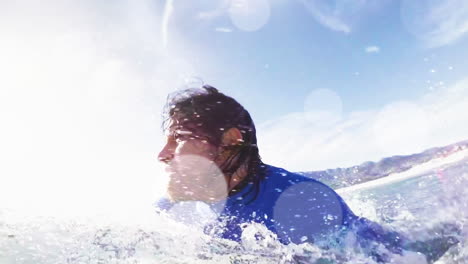 animation of lights and bokeh over happy caucasian male surfer surfing on waves