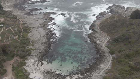 AERIAL---Rocky-bay-in-Zapallar,-Valparaiso,-Chile,-wide-static-shot