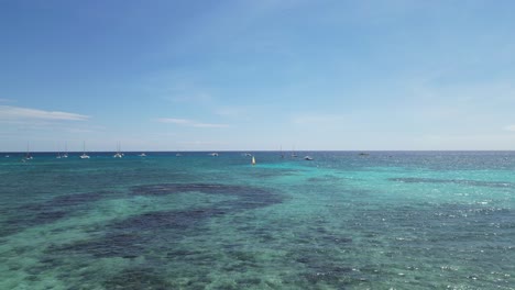 Aerial-landscape-shot-of-people-and-boats-on-the-beach-of-Bayahibe-in-Dominican-Republic-during-a-sunny-day