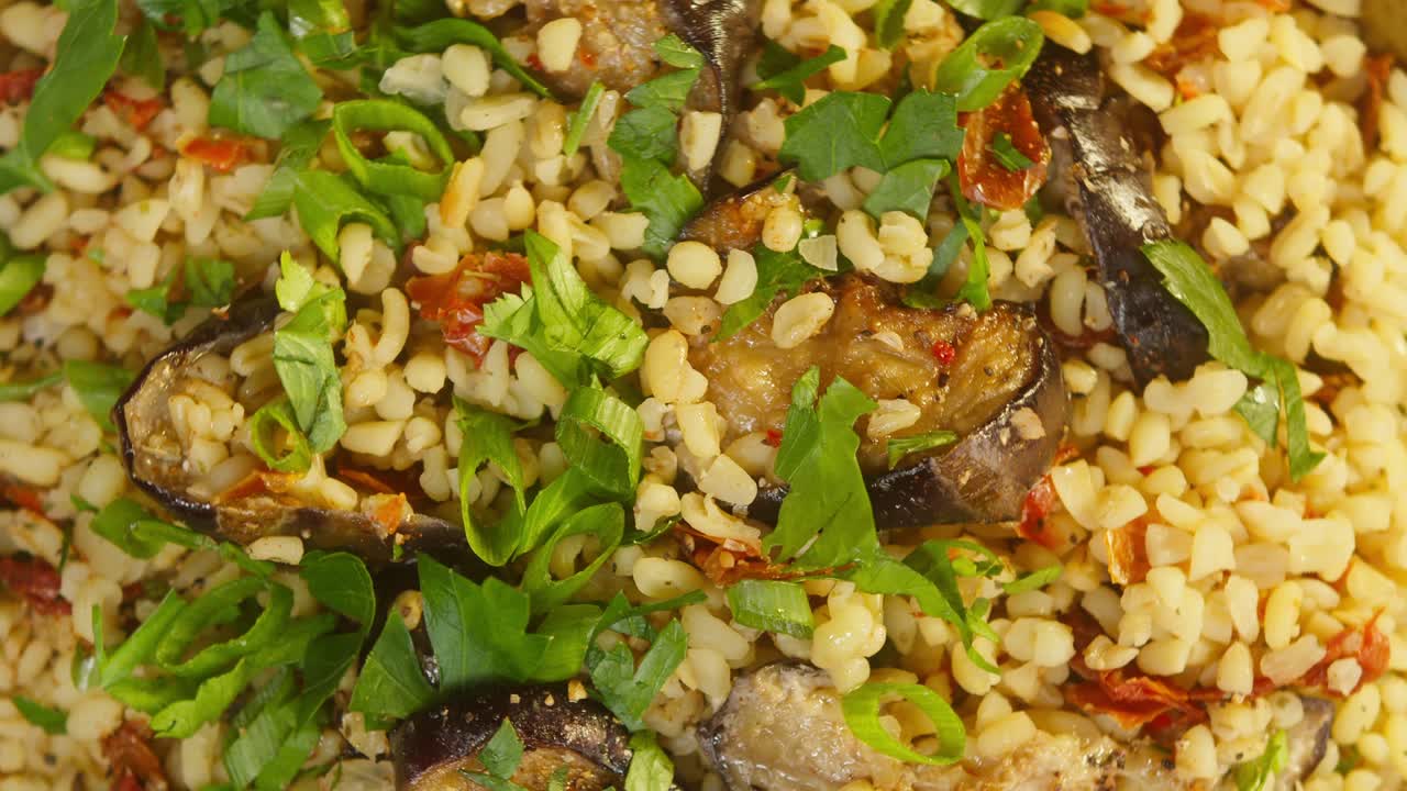 bulgur con berenjena y vegetación rotación de primer plano. cultura tradicional de oriente medio. delicioso arroz con carne. cocina árabe. concepto de comida casera