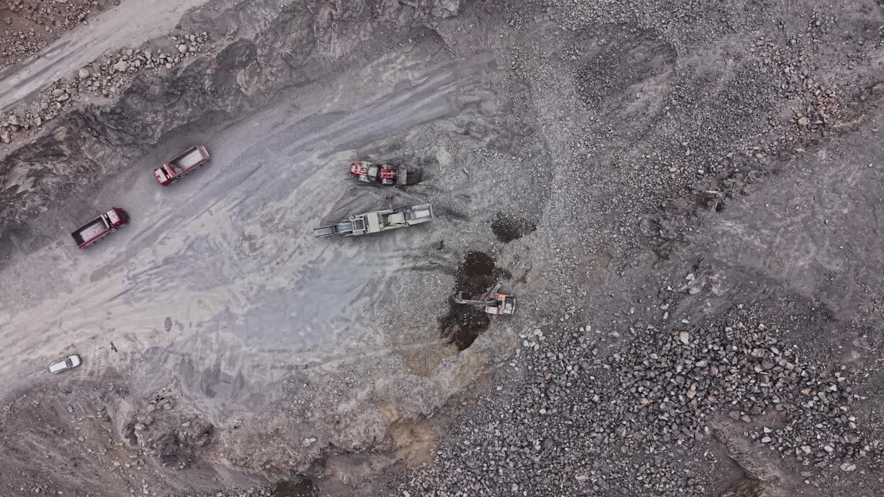 Heavy machinery working in a stone quarry during daylight hours