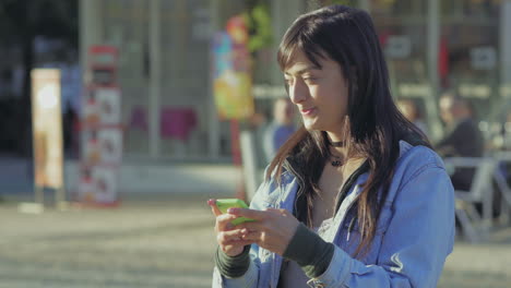 Smiling-teenage-girl-texting-on-smartphone.