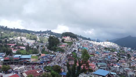 Panoramic-drone-shot-of-Kodaikanal-town-and-Sacred-Heart-Catholic-Church-under-overcast-sky,-Dindigul,-Tamil-Nadu,-India