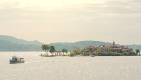 Aerial-shot-of-a-ferry-leaving-isola-superiore,-borromean-island-in-lago-maggiore