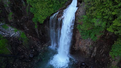 Scenic-high-orbital-shot-of-cascading-waterfall-off-of-cliff-side-in-Evergreen-Forest-in-the-Pacific-Northwest