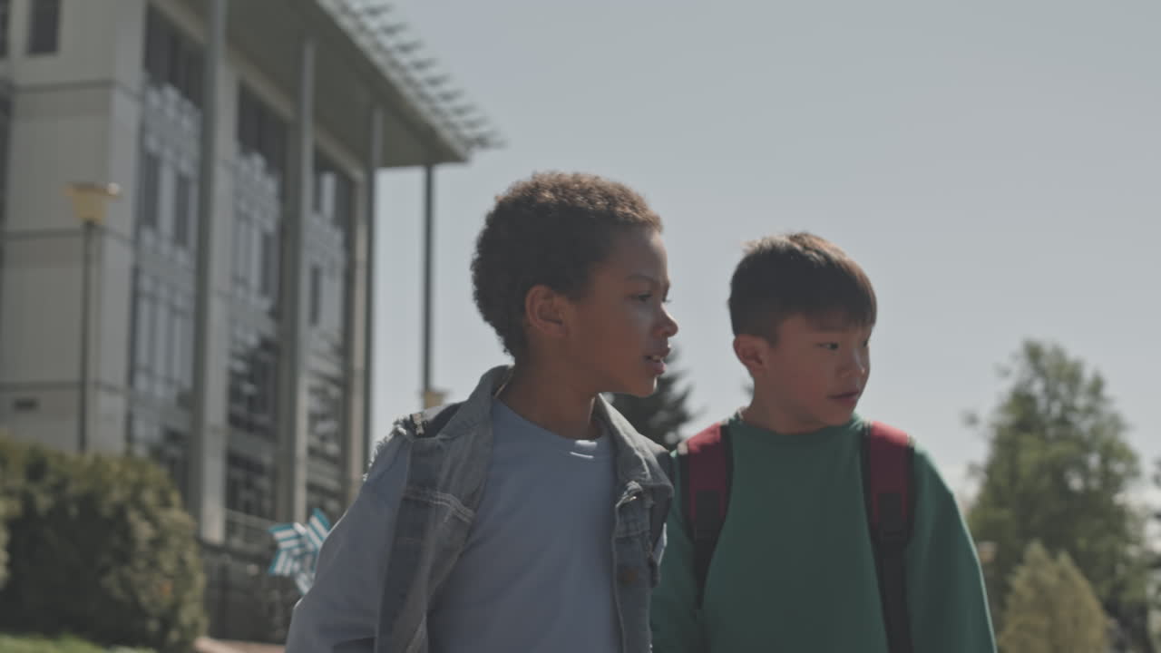 Two school kids with backpacks on campus