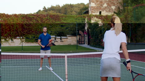 vista trasera de una mujer deportiva jugando tenis con un hombre en una cancha al aire libre en un día de verano 1