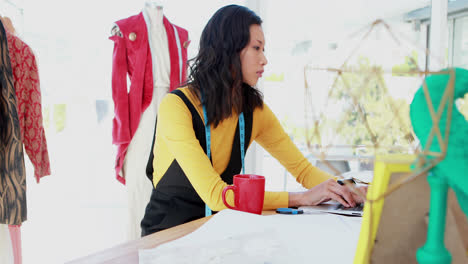 Female-designer-using-laptop-on-desk-4k