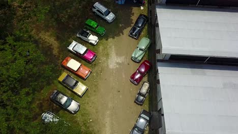 colorful collection of antique vintage classic cars overhead tilt down drone shot