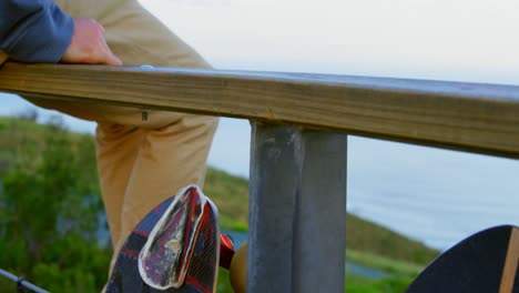 Close-up-of-young-caucasian-skateboarders-holding-hands-at-observation-point-4k