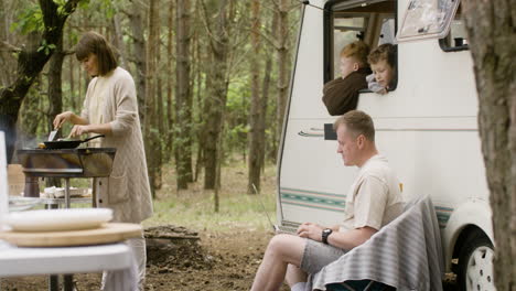 familia nómada feliz pasando tiempo juntos en el campamento en el bosque