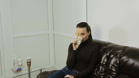 woman with eye patch. young woman drinking cup of coffee and waiting at reception in clinic