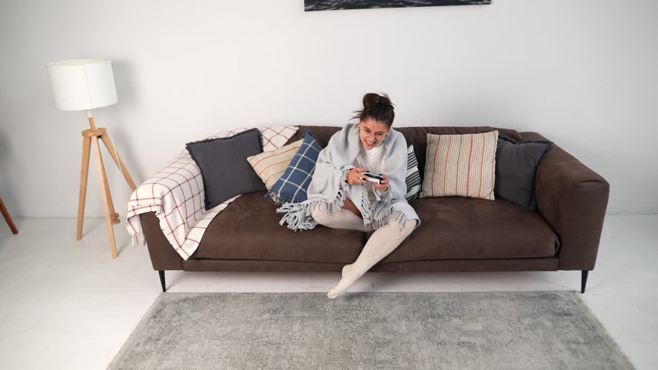 mujer relajándose en un sofá, jugando videojuegos