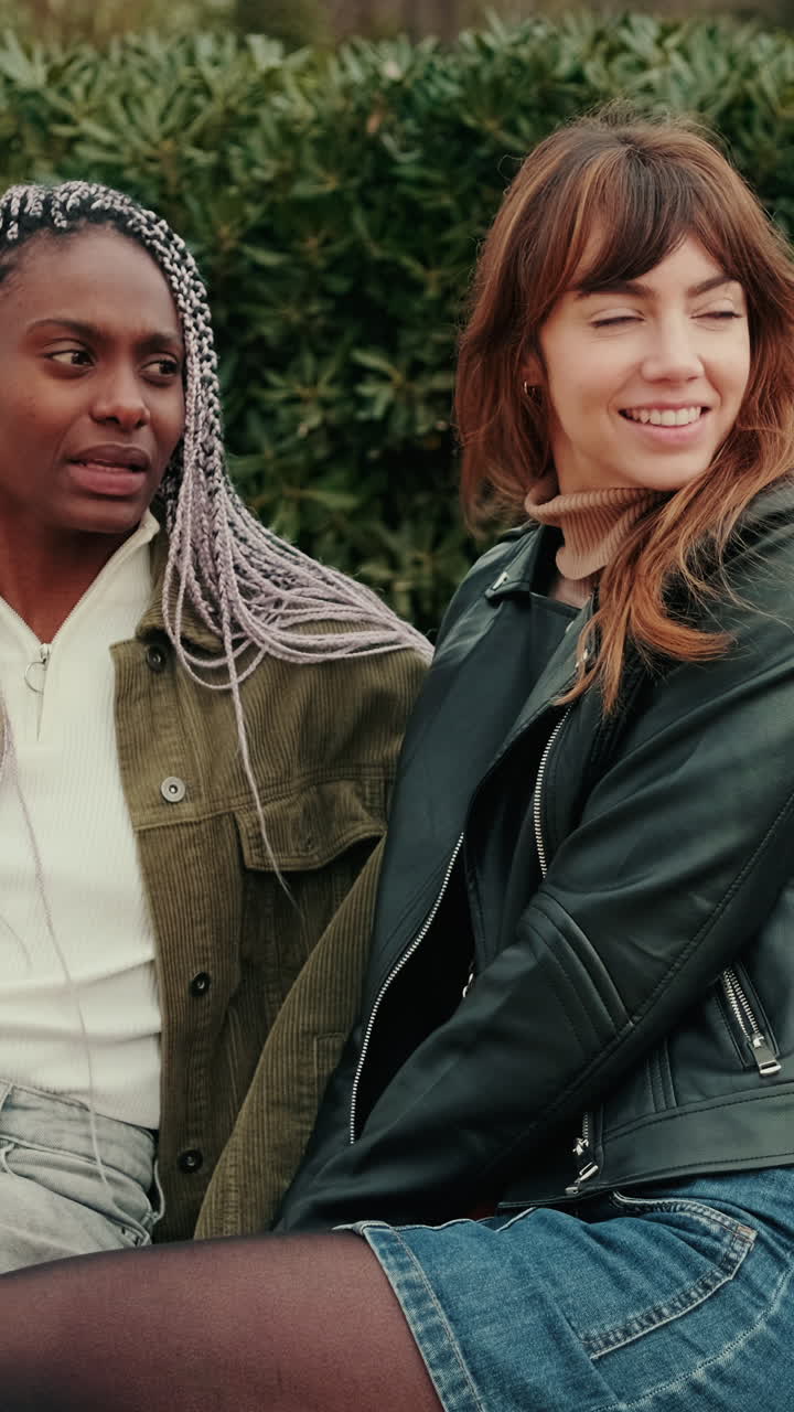 Lachende, multiculturele vrienden genieten buiten van een gesprek